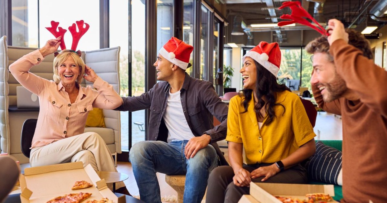 Employees Celebrating With Christmas Party And Meal In Office